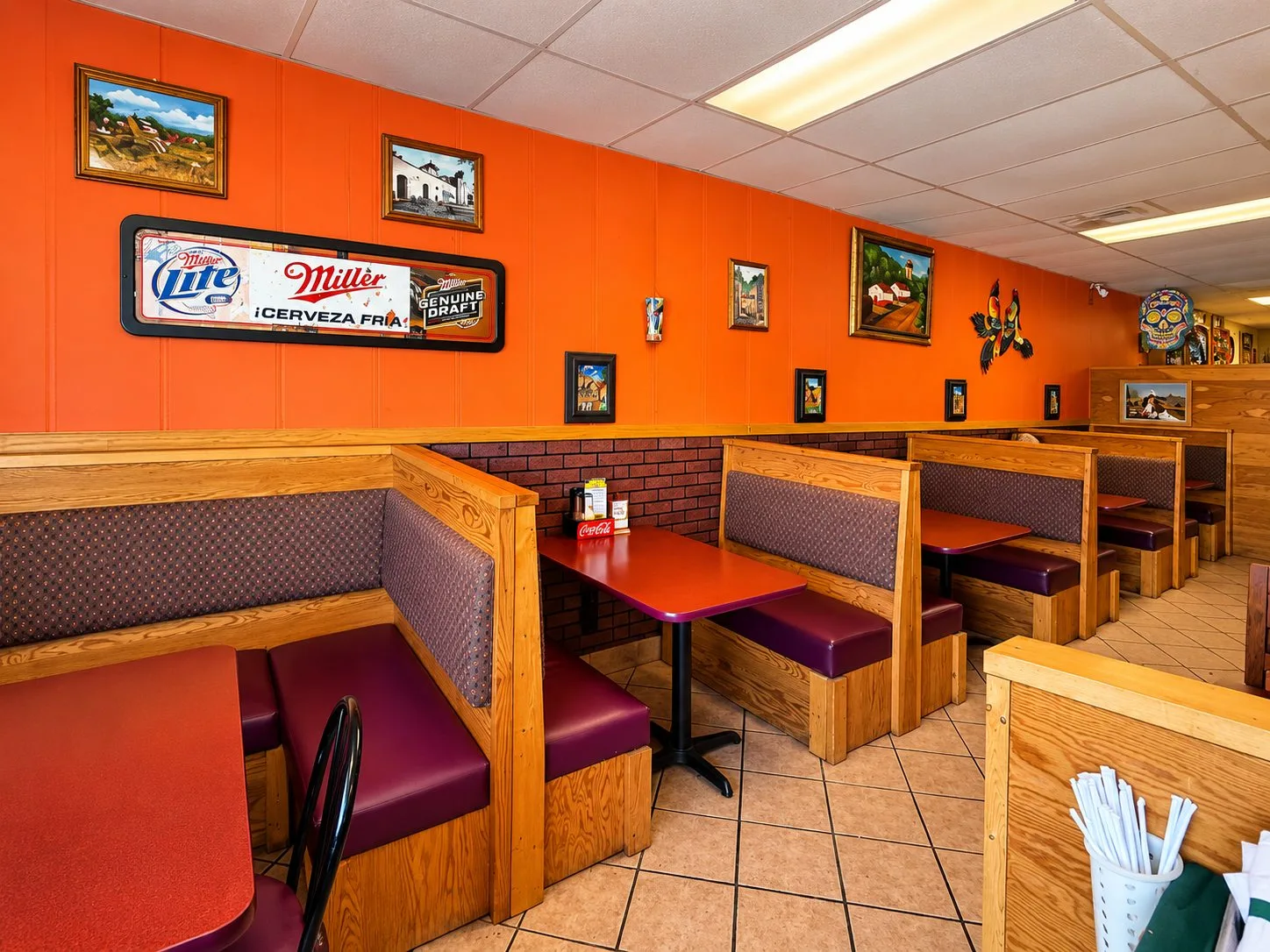 Booth seating beneath colorful Mexican artwork inside Mariachi Fiesta