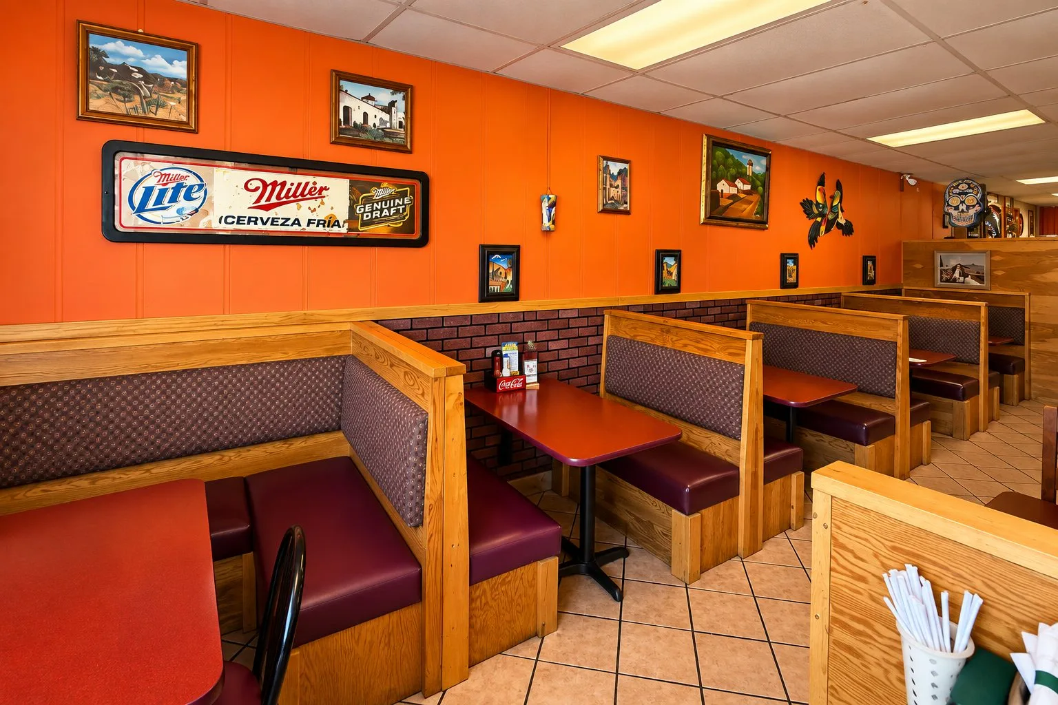 A row of comfortable booths and Mexican artwork inside Mariachi Fiesta